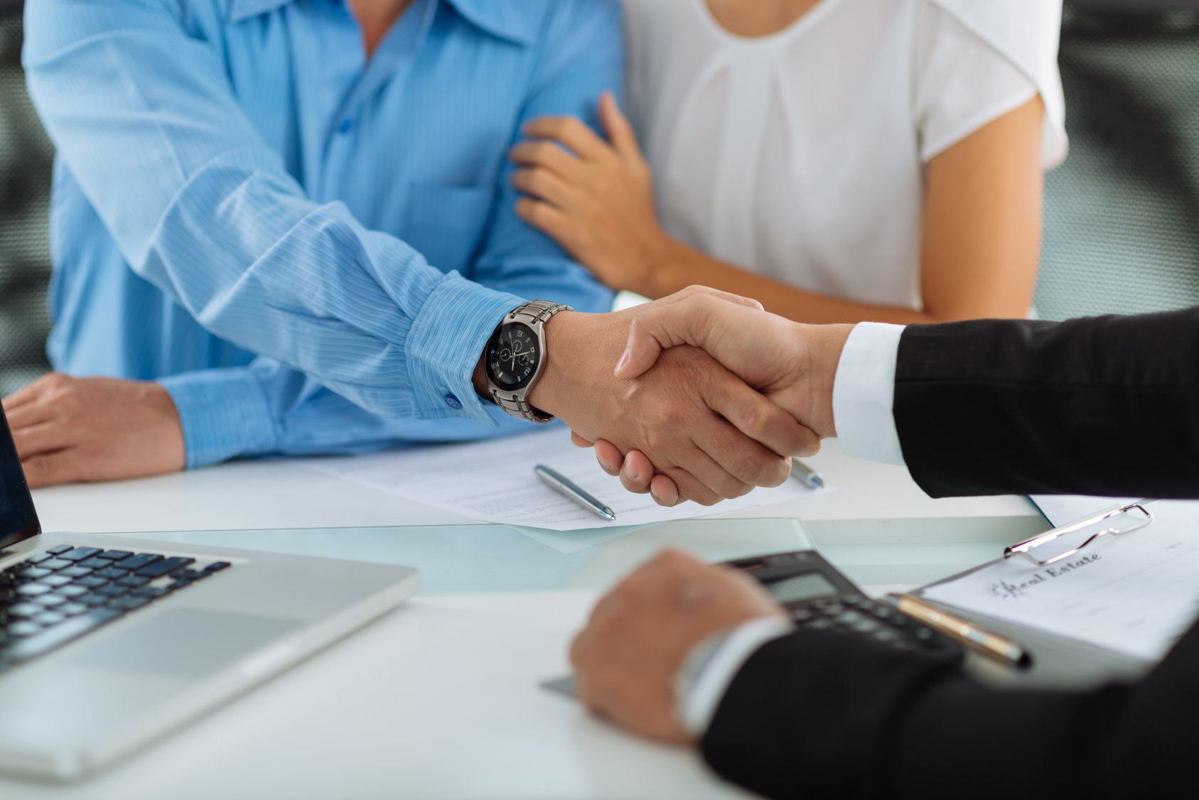 Close-up image of real estate agent and his client shaking hands